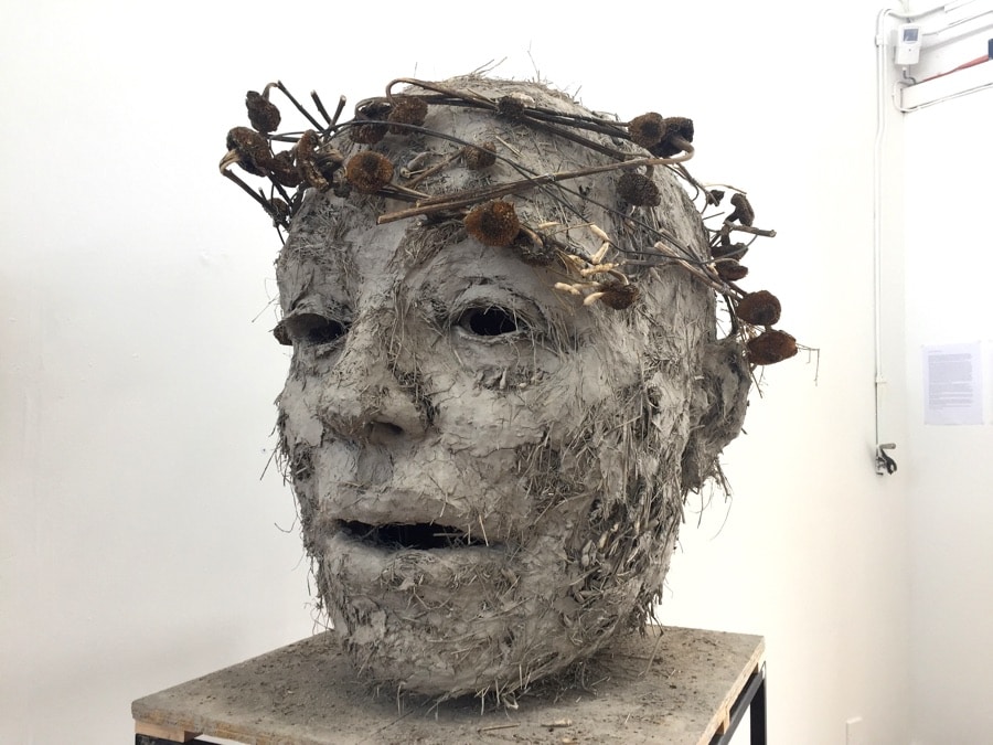 giant sculpture of a head made of clay and straw